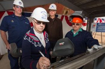 The cutter’s sponsor, Jazania O’Neal, writes her initials onto a steel plate that will be affixed to Midgett, the service’s eighth national security cutter.