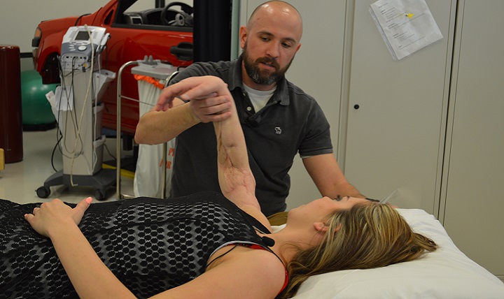 Christopher Ebner, occupational therapist, exercises Kelsey Ward's arm at the Center for the Intrepid. Ward's arm was severed when a guardrail pierced the passenger-side window of her SUV in a car wreck. BAMC surgeons performed their first above-the-elbow arm replant on the 22-year-old trauma patient and almost 10 months later, she is thriving. (U.S. Army photo by Lori Newman)