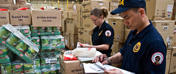 Two FDA inspectors checking products in a warehouse