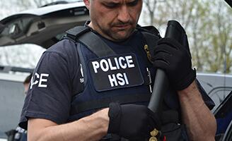 HSI Agent standing in front of vehicle