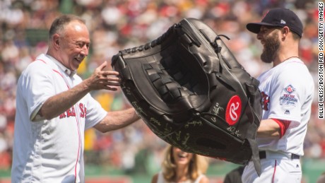 BOSTON, MA - AUGUST 20: Dustin Pedroia #15 of the Boston Red Sox presents NESN broadcaster Jerry Remy with a giant glove as a gift during a 30 year recognition ceremony before a game between the Boston Red Sox and the New York Yankees on August 20, 2017 at Fenway Park in Boston, Massachusetts. (Photo by Billie Weiss/Boston Red Sox/Getty Images)