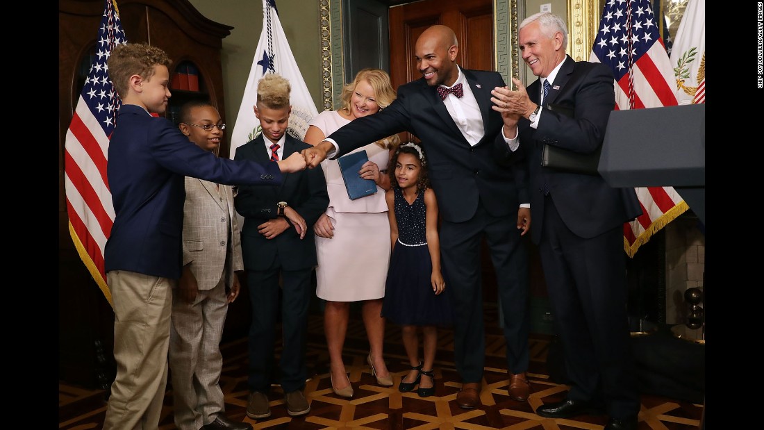 Dr. Jerome Adams, &lt;a href=&quot;http://www.cnn.com/2017/08/04/health/jerome-adams-surgeon-general-confirmation/index.html&quot; target=&quot;_blank&quot;&gt;the new surgeon general&lt;/a&gt; of the United States, fist-bumps one of his sons after being sworn in by Vice President Mike Pence on Tuesday, September 5.