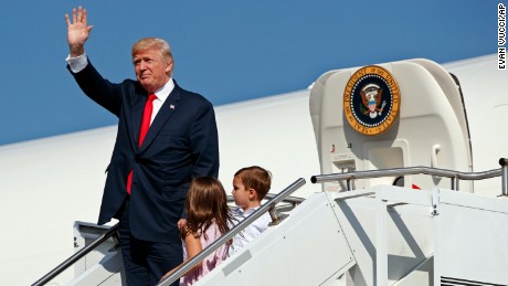 President Donald Trump waves as he walks down the steps of Air Force One with his grandchildren, Arabella Kushner, center, and Joseph Kushner, right, after arriving at Morristown Municipal Airport to begin his summer vacation at his Bedminster golf club, Friday, Aug. 4, 2017, in Morristown, N.J. (AP Photo/Evan Vucci)