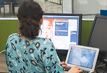 person sitting at a dual monitor station