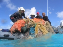 People pulling up derelict fishing nets.