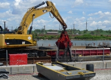 A mechanical dredge removing sediment near a body of water. 