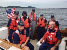 A group of people on a boat posing for a photo. 