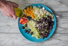 Olive oil being poured on a salad. 