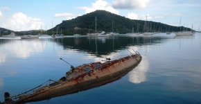 A derelict vessel is partially submerged in Coral Bay. 