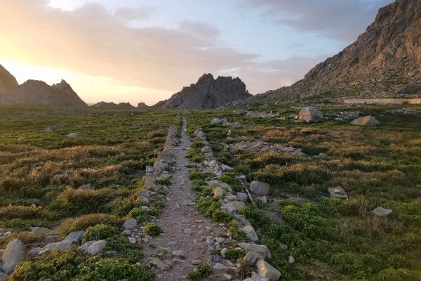 A view of a rocky hillside at sunset. 