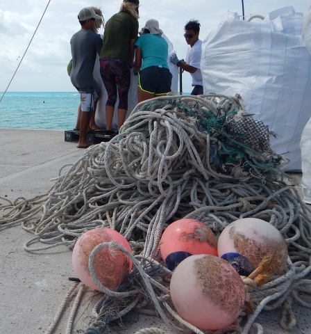 The team piles heaps of derelict fishing nets into bagsters on the pier at Tern Island.