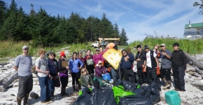 Students gather around several bags of trash. 