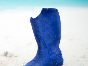 A rubber boot washed up on the sandy shores of North Beach, Sand Island, Midway Atoll.