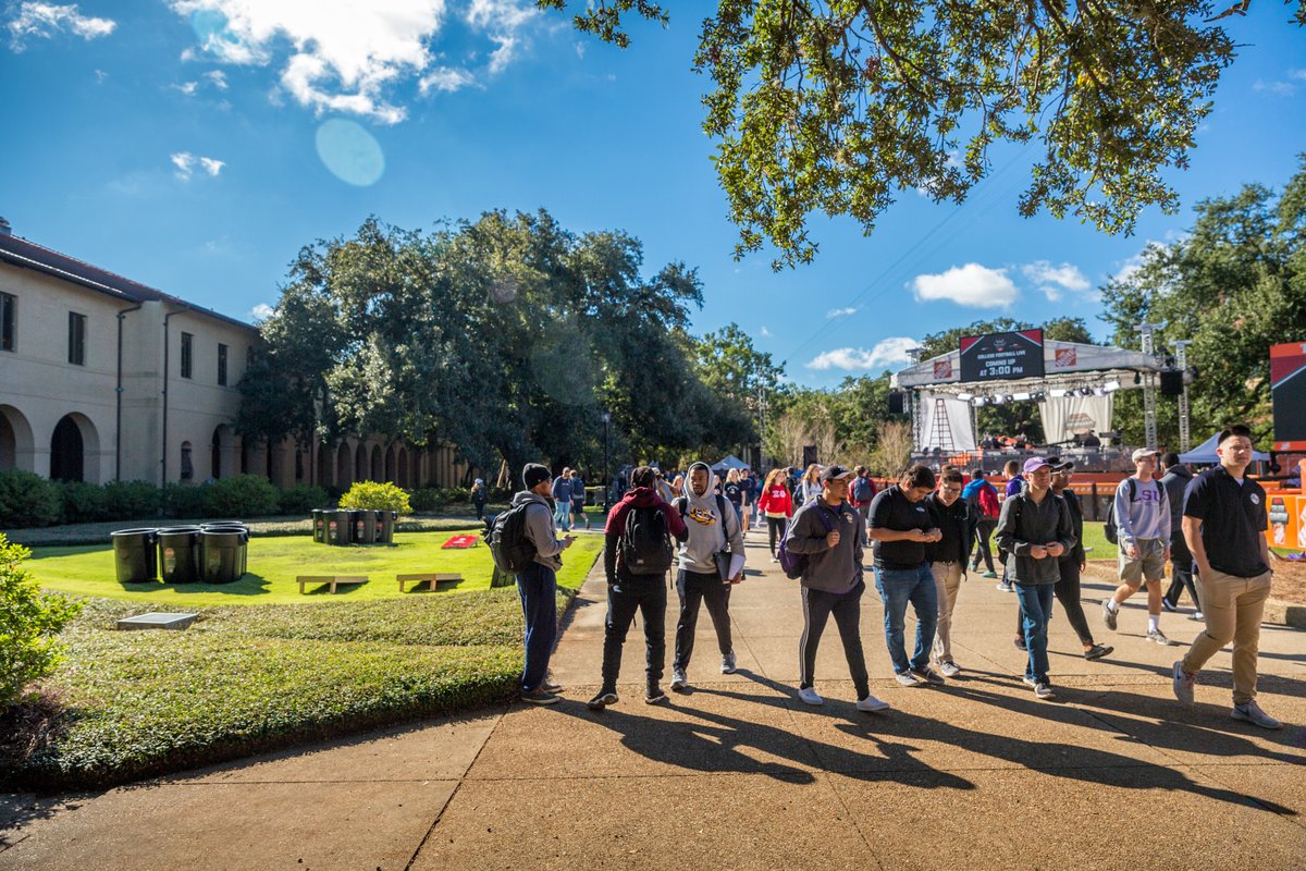 Students walk through the Quad with the ESPN College GameDay set in the background.