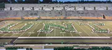 students creating letters UNT on football field
