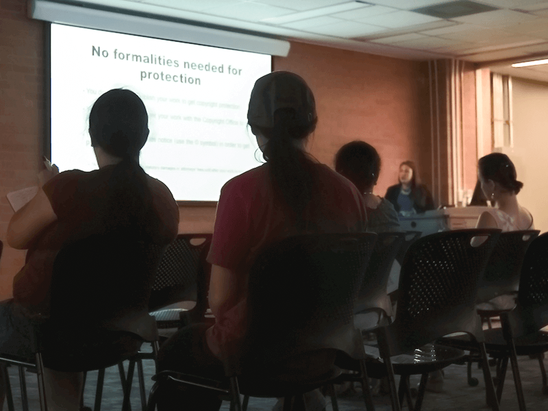 people sitting in chairs looking at a presentation screen