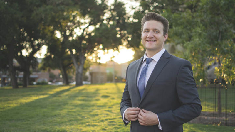 Chris McGinty standing outside against sunrise