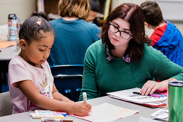 A student teacher works with a child at Ginnings Elementary School