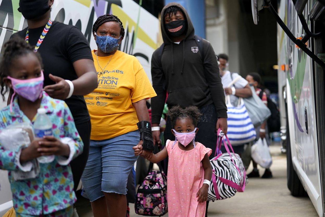 Families board a bus to evacuate Lake Charles, La. (AP)