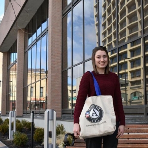 Erin holding a bag outside of program site. 