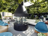 A large fireplace and funky furniture are pictured on the Catbird outdoor patio area of the 219-room Thompson Dallas luxury hotel. (Tom Fox/The Dallas Morning News)