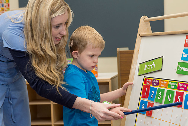 UNT faculty working with a child.