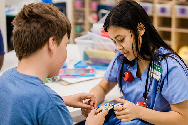 A staff member at the UNT Autism Center works with a young boy