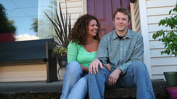 Couple smiles while sitting on their porch