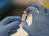 A worker holds a bottle of the Pfizer-BioNTech COVID-19 vaccine, as the mass public vaccination program gets underway at Southmead Hospital in Bristol, England, Tuesday Dec. 8, 2020. The United Kingdom, one of the countries hardest hit by the coronavirus, is beginning its vaccination campaign to inoculate people against the COVID-19 virus. (Graeme Robertson/Pool via AP)