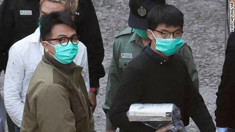 Hong Kong activists Joshua Wong, right, and Ivan Lam, left, are escorted by Correctional Services officers to get on a prison van before appearing in a court, in Hong Kong, Wednesday, Dec. 2, 2020. Prominent Hong Kong pro-democracy activist Wong and two other activists, Lam and Agnes Chow, were taken into custody after they pleaded guilty to charges related to a demonstration outside police headquarters during anti-government protests last year. (AP Photo/Kin Cheung)