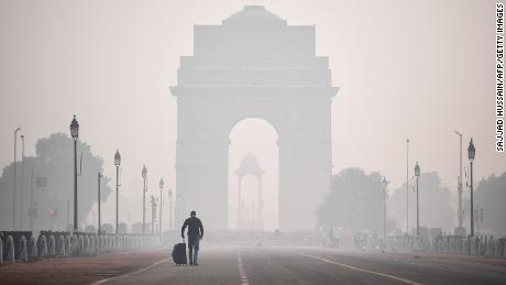 A man walks along the Rajpath street near India Gate amid smoggy conditions a day after Diwali, the Hindu festival of lights, in New Delhi on November 15, 2020. (Photo by Sajjad HUSSAIN / AFP) (Photo by SAJJAD HUSSAIN/AFP via Getty Images)