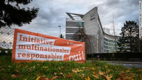 A picture taken on November 19, 2020, next to the headquarters of Swiss food giant Nestle in Vevey shows a campaign banner reading in French: &quot;Corporate responsibility initiative, Yes!&quot; ahead of a November 29, 2020 nationwide vote on a people&#39;s initiative to impose due diligence rules on Swiss-based firms active abroad. - Swiss voters will decide on November 29, 2020, whether to impose the world&#39;s strictest corporate responsibility rules, making multinationals headquartered in the country liable for their and their partners&#39; abusive business practices worldwide. (Photo by Fabrice Coffrini/Getty Images)