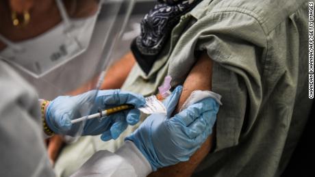 Thomas Hansler, 54, receives a COVID-19 vaccination from Yaquelin De La Cruz at the Research Centers of America in Hollywood, Florida on August 13, 2020. (Photo by CHANDAN KHANNA / AFP) (Photo by CHANDAN KHANNA/AFP via Getty Images)