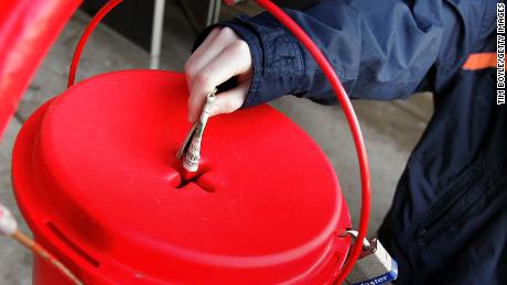 PARK RIDGE, IL - DECEMBER 20: A donation is made into Salvation Army bell ringer Juanita Brown&#39;s red Holiday donation kettle December 20, 2005 in Park Ridge, Illinois. Since 1865, the Salvation Army has been helping the needy and every year close to 33 million people in the U.S. receive help from the Salvation Army. (Photo by Tim Boyle/Getty Images)