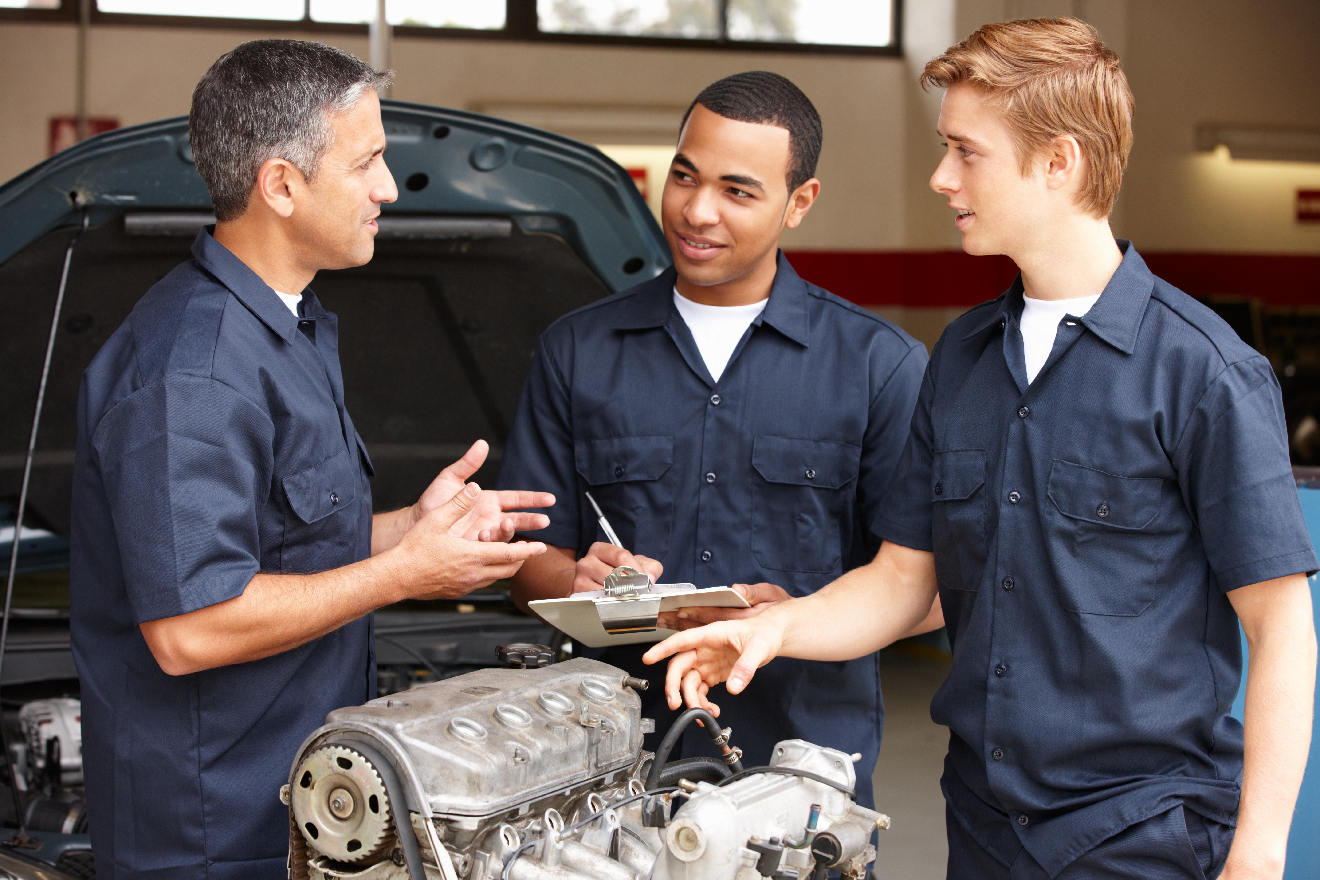 Three men in manufacturing speaking together