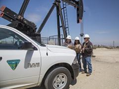BLM workers in front of a pump jack. 