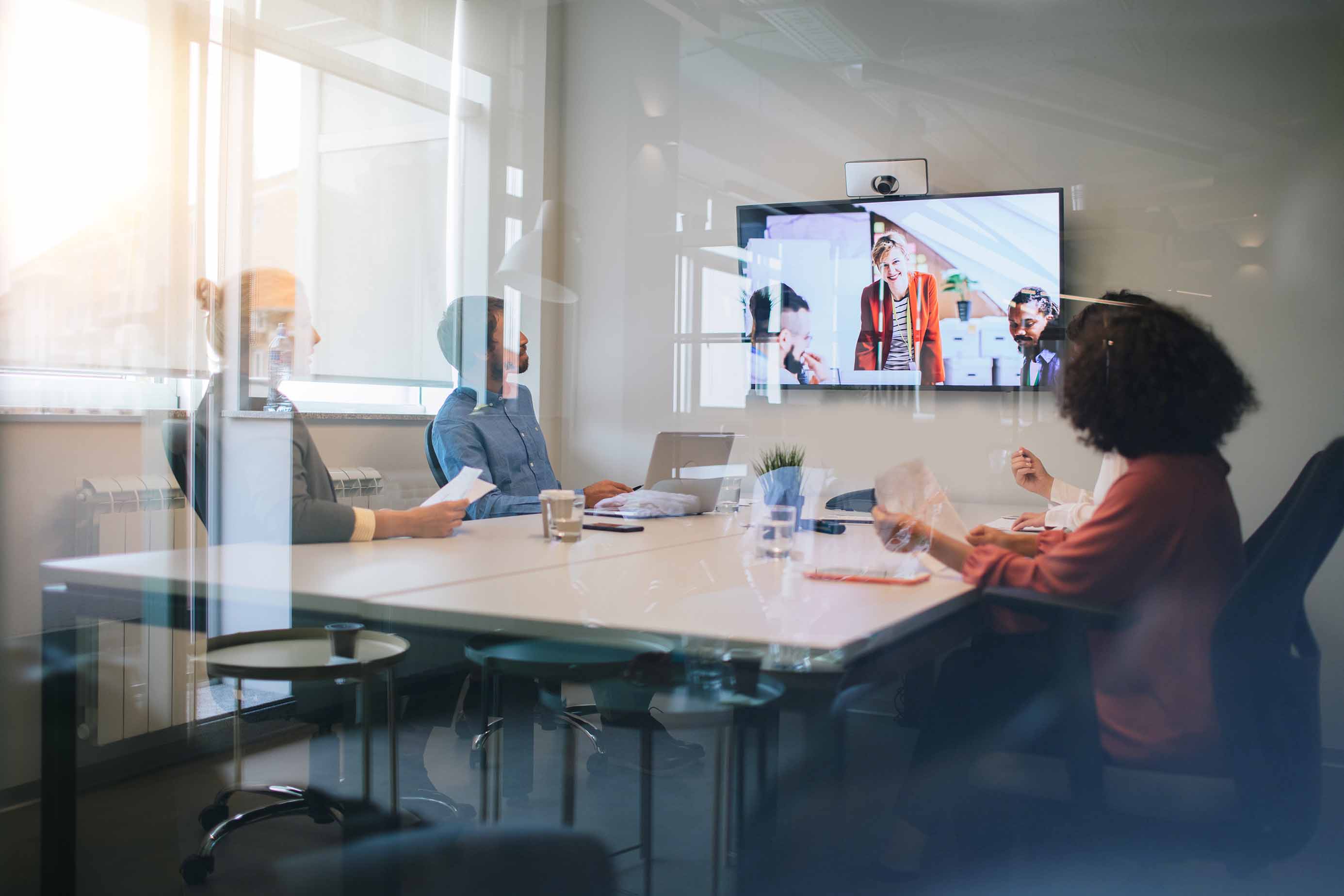 three people, on virtual, attend a business meeting in a conference room