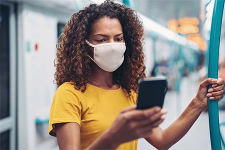 woman wearing a mask and looking at her phone