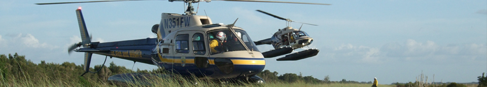 Two helicopters with floats preparing for takeoff