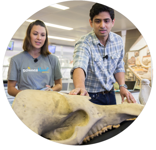 A Smithsonian educator and scientist observe a fossil. 