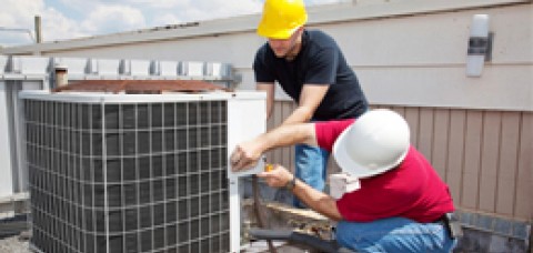 Two men working on an air conditioner