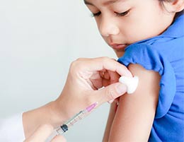 A child receiving an injection from a clinician.