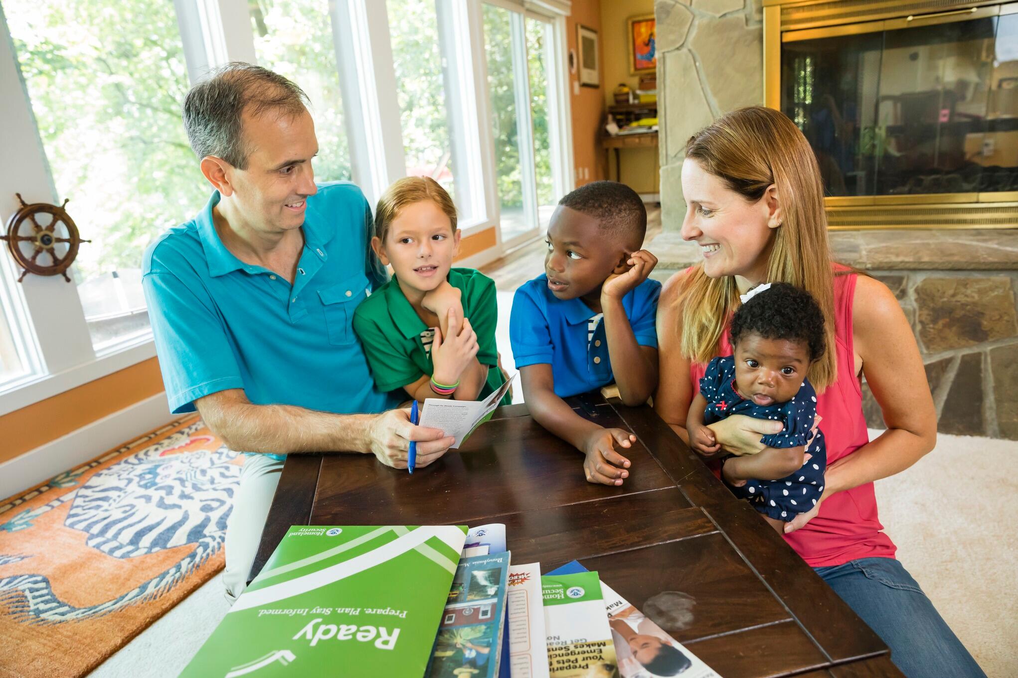 Family of 5 preparing for emergency checking emergency preparedness list