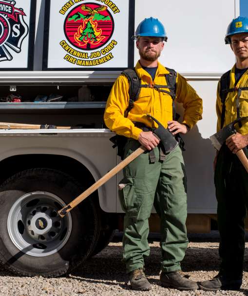 Wildland firefighters stand with firefighting gear