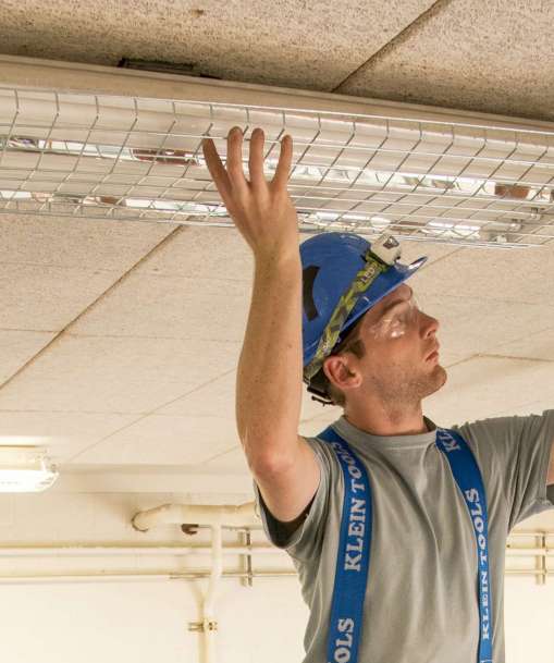 A man adjusts a ceiling light fixture