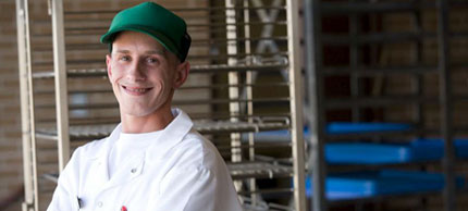 Photo of man by food trays.