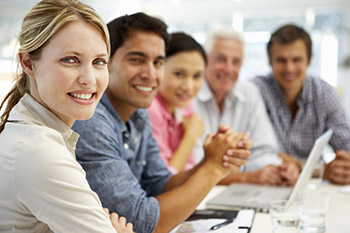 A group of health care professionals in a meeting and sitting at a table.