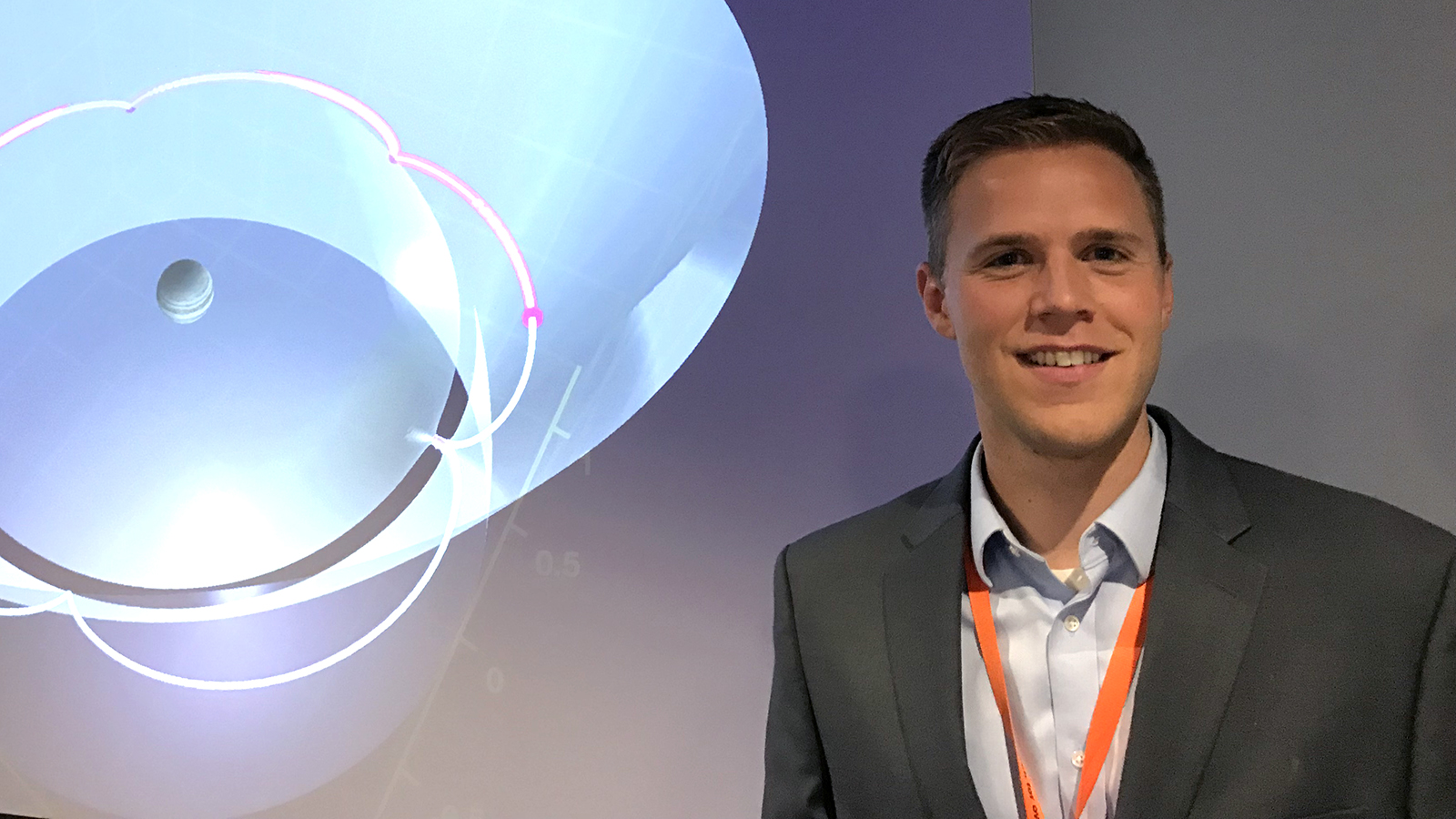 Jared Blanchard poses in front of a visualization in the VIVID lab at JPL.