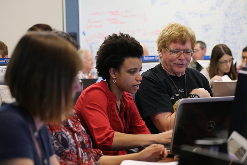 Watkins and Smythe look at a computer screen together