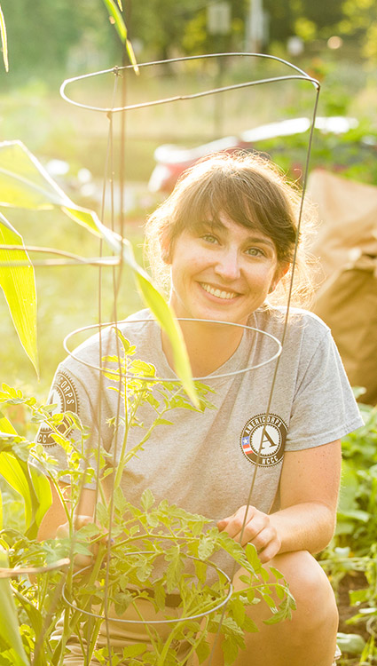 AmeriCorps NCCC member working in garden at project site. 